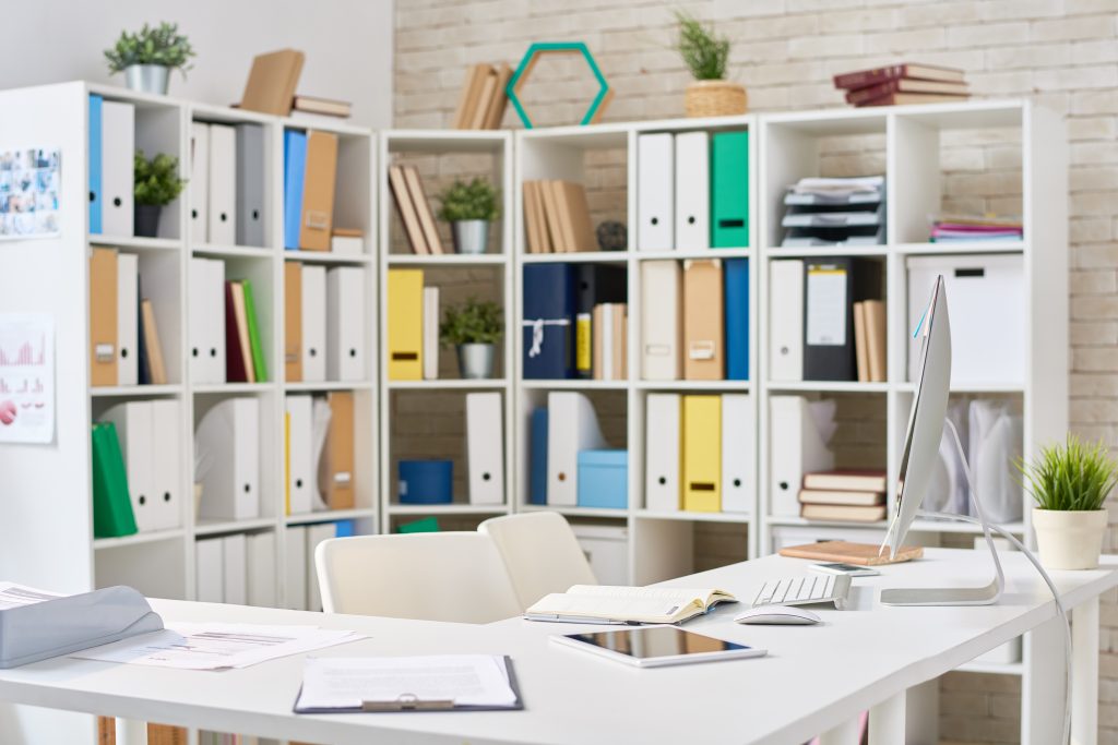 Bright Brooklyn office space with white shelving, desk, computer, and files creates an organized and efficient work environment in New York, NY.