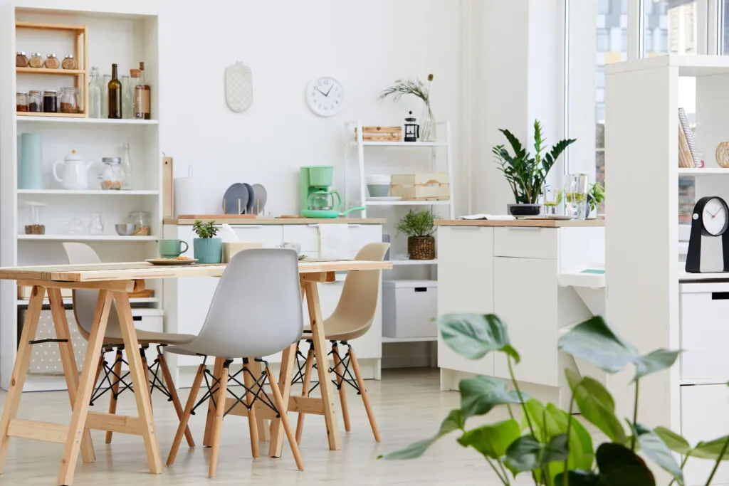 A bright, well-kept kitchen with stocked open shelves and a dining table